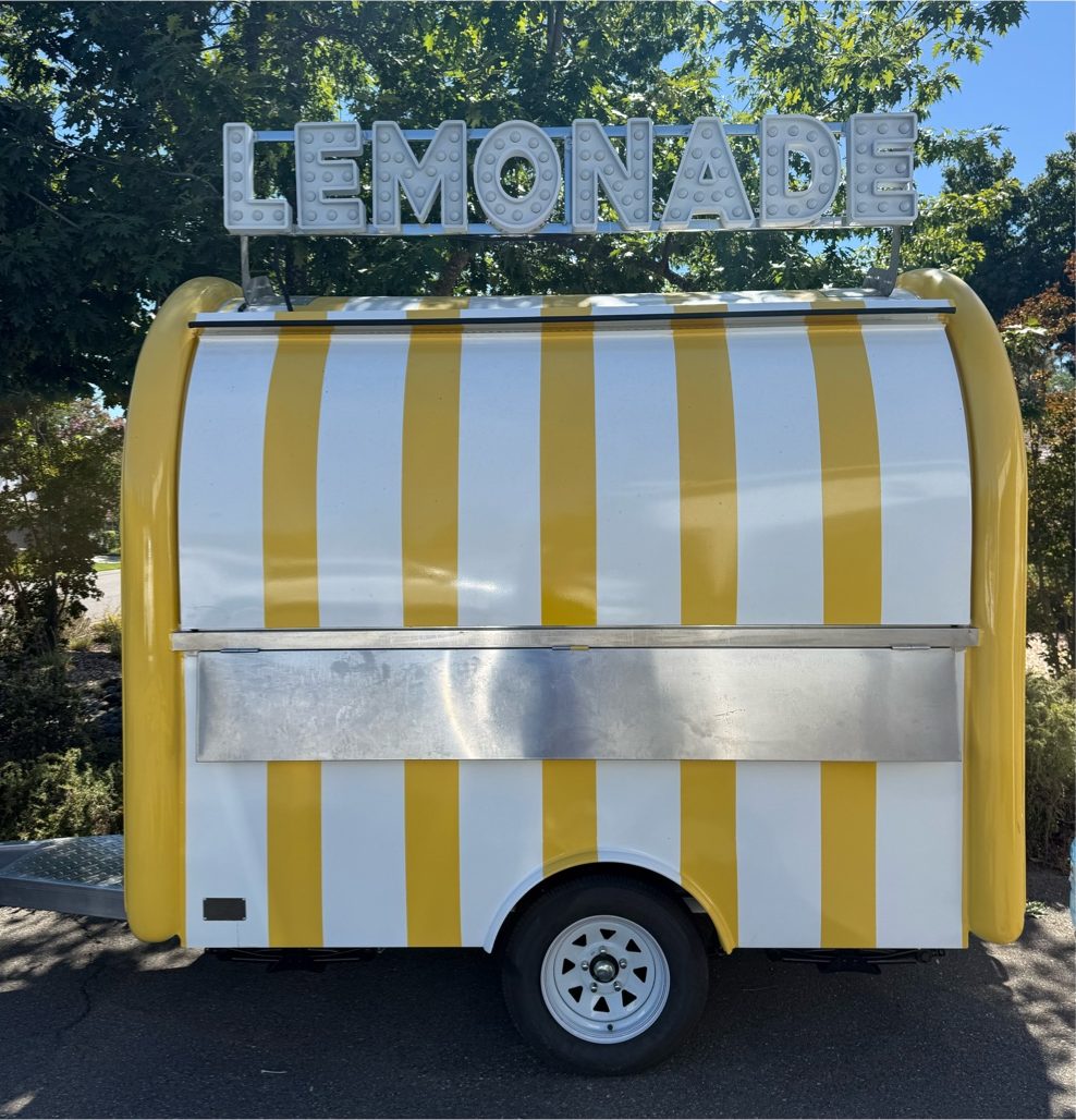 Side view of the yellow and white striped lemonade trailer