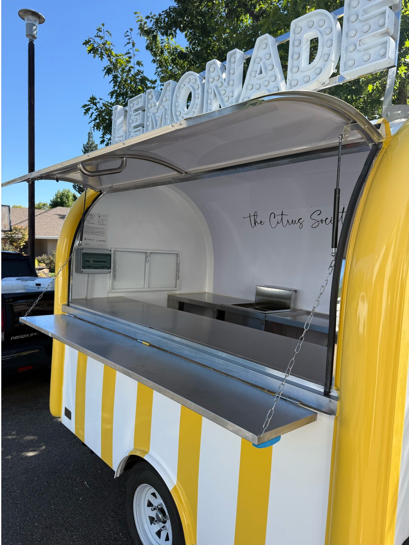 The Citrus Society trailer with its serving window open and awning raised